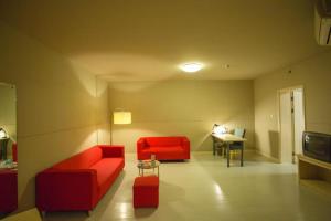 a living room with a red couch and a table at Jinjiang Inn Shanghai Songjiang University Town in Chengxi