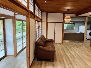 Una sala de estar con un sofá de cuero y una cocina. en HOTEL DanDan, en Shuzenji
