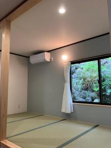 Una habitación con una ventana con un vestido colgando de ella. en HOTEL DanDan, en Shuzenji
