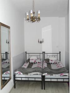 a bedroom with a bed with a mirror and a chandelier at Apartament MARIA in Gdańsk