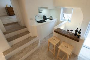 a small kitchen with a counter and some bottles of wine at Casaterramare in Ostuni