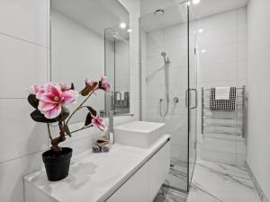 un bagno bianco con lavandino e pianta in vaso di Remarkable QT - Queenstown Holiday Home a Queenstown Altre 15 foto