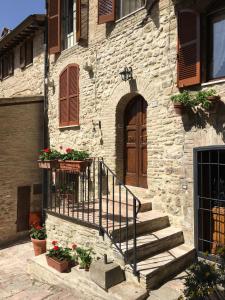 a stone building with stairs and a wooden door at Il Sementone in Assisi