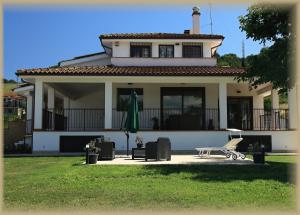 a white house with a green umbrella in front of it at Just House in Campagnano di Roma