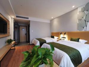 a hotel room with two beds and a flat screen tv at GreenTree Inn Ganzhou Gan County Bus Station in Meilin +229 photos