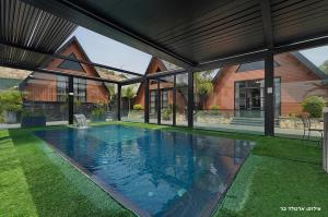 a swimming pool in front of a house at Campanga nera - ארבע בקתות מדהימות עם בריכה מחוממת וג'קוזי in Yarka +33 photos