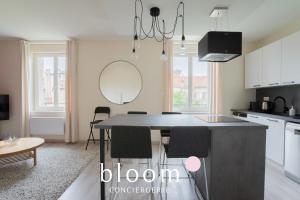a kitchen with a table with chairs and a mirror at Le Solignac appartement neuf et tout équipé in Nancy