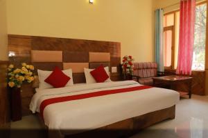 a bedroom with a large bed with red pillows at The Mountain Paradise in Rewalsar +24 photos