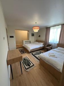 a bedroom with two beds and a chandelier at Sandyk At-Bashy Hotel in At-Bashy