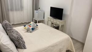a small room with a bed and a television at Camelia's House in Olbia