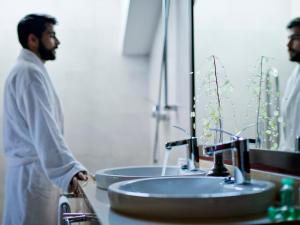 a man standing in front of a bathroom sink at The Cookbook Gastro Boutique Hotel & SPA in Calpe