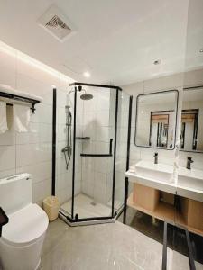 a bathroom with a shower and a toilet and a sink at GreenTree Inn Langfang GuanGYAng District GuanGYAng Road City Government Express Hotel in Nanjianta