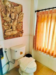 a bathroom with a toilet and a painting on the wall at Pludhaya Resort & Spa in Phra Nakhon Si Ayutthaya +61 photos