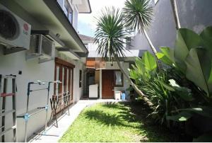 an outside view of a house with plants in the yard at Stylish House Near Pakuwon Mall in Kejayan