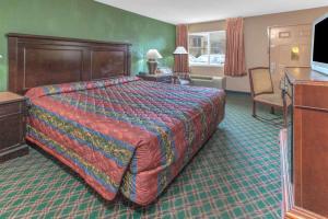 une chambre d'hôtel avec un grand lit et un salon dans l'établissement Knights Inn - Forest Hill, TX, à Forest Hill