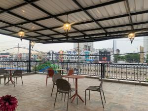 a patio with tables and chairs and a view of a city at The Tasqya Syariah in Sultan Syarif Kasim II International Airport