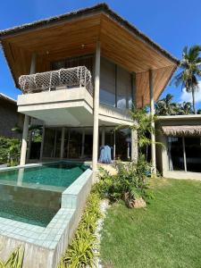 a house with a swimming pool in front of it at Aqualina Villa, Carbana Lodge, A Hidden Gem in Koh Samui