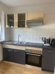 a kitchen with a sink and a stove at Fewo Zentral-Living in Kempten +5 photos