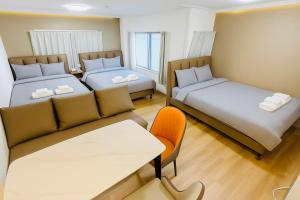 two beds and a couch in a room at Lucky NAMBA MINAMI 大阪難波 なんば in Osaka