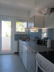 a kitchen with white cabinets and a counter top at Appartement Le Cap in Toulon