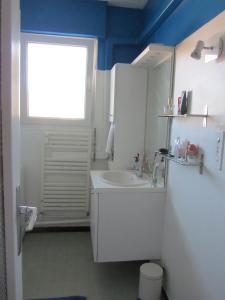 baño con lavabo blanco y ventana en Appartement Le Cap, en Toulon