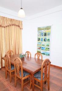 une table à manger en bois avec quatre chaises dans l'établissement Royal Palace Heritage, à Nuwara Eliya