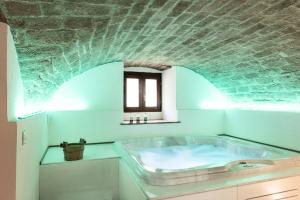 Albergo Il Rientro في Cannara: حوض استحمام في حمام مع سقف من الطوب