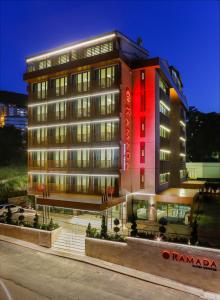 a tall building with a red building at Ramada By Wyndham Bursa Cekirge Thermal & Spa in Bursa