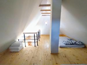 a attic room with a bed and a staircase at Sunset sauna Bauska in Jumprava