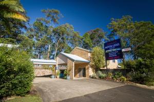 un bâtiment avec un panneau indiquant un nouvel espoir dans l'établissement Sunshine Coast Motor Lodge, à Woombye