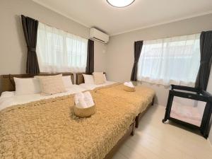 a bedroom with two beds with white pillows at Grande Ortho Okinawa Villa Onna 3 - Vacation STAY 83615 in Onna