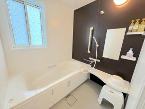 a white bathroom with a tub and a toilet at Grande Ortho Okinawa Villa Onna 3 - Vacation STAY 83615 in Onna +34 photos