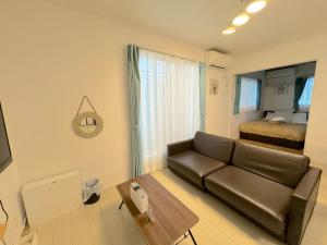 ein Wohnzimmer mit einer Couch und einem Bett in der Unterkunft Grande Ortho Okinawa Villa Onna 3 - Vacation STAY 91374 in Meta