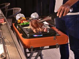 a man is cooking meat on a grill at Rakuten STAY VILLA Awaji 102 3 bank beds, Capacity of 9 persons in Minamiawaji