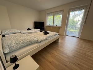 BiberbachにあるWundP Living Wohnung mit Terrasse Parkplatzのベッドが2つと大きな窓がある寝室
