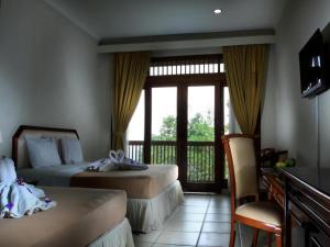 a hotel room with two beds and a balcony at d'Emmerick Salib Putih Hotel Salatiga in Salatiga