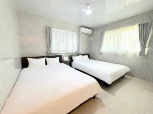 two beds in a small room with white sheets at Grande Ortho Okinawa Villa Onna 3 - Vacation STAY 91370 in Onna