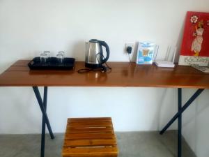 a wooden table with a coffee maker on top of it at Diamond shine hostal and bunk beds in Kandy
