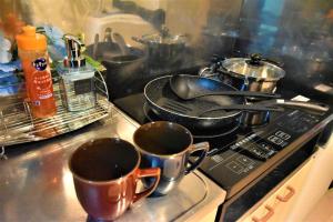a stove top with two cups and pots and pans at Tresor Misono - Vacation STAY 9333 in Toyohira