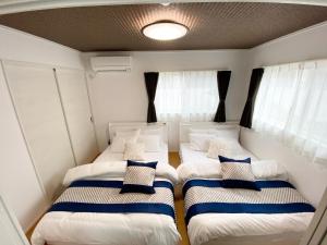 two beds in a small room with windows at Grande Ortho Okinawa Villa Onna 3 - Vacation STAY 83617 in Onna