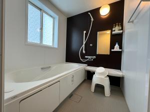 a white bathroom with a tub and a sink at Grande Ortho Okinawa Villa Onna 3 - Vacation STAY 83617 in Onna +34 photos