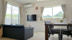a living room with a couch and a table with chairs at Grande Ortho Okinawa Villa Onna 3 - Vacation STAY 83617 in Onna
