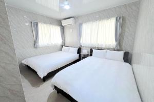 a bedroom with two beds and two windows at Grande Ortho Okinawa Villa Onna 3 - Vacation STAY 91321 in Onna