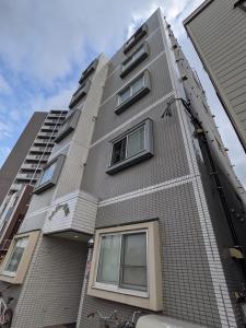 a tall grey building with windows on the side at Tresor Misono - Vacation STAY 14287 in Sapporo