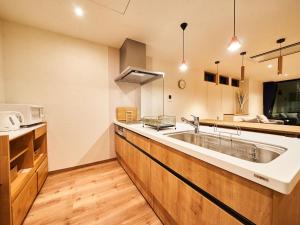 a kitchen with a large sink and a microwave at Rakuten STAY HOUSE Kujukuri Ichinomiya 104 3LDK with BBQ terrace in Ichinomiya +38 photos