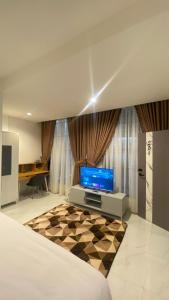Sultan Syarif Kasim II International AirportにあるThe Tasqya Syariahのベッドとテレビのある寝室