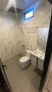 Sultan Syarif Kasim II International AirportにあるThe Tasqya Syariahのトイレと洗面台を備えた白いバスルーム