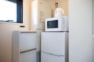 a microwave on top of two refrigerators in a room at Tokyo WEST Laffite - Vacation STAY 8298 in Ogikubo
