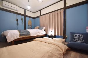 two beds in a room with blue walls at Shinozaki Kodate - Vacation STAY 16392 in Tokyo