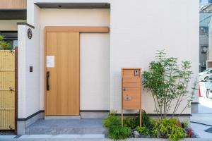 a house with a wooden door and a dresser at Apartment Hotel 11 Villa Hanazonocho in Osaka